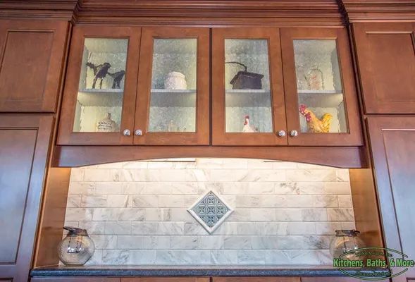A kitchen with wooden cabinets and glass doors.