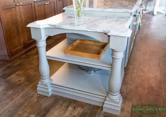 A kitchen island with a marble counter top and a tray on it.
