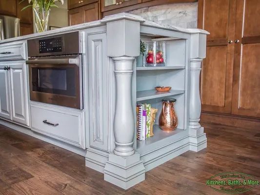 A kitchen with a large island and a microwave oven.