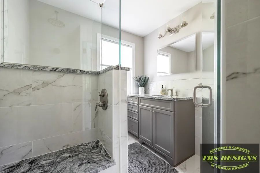 A bathroom with a walk in shower and a sink.