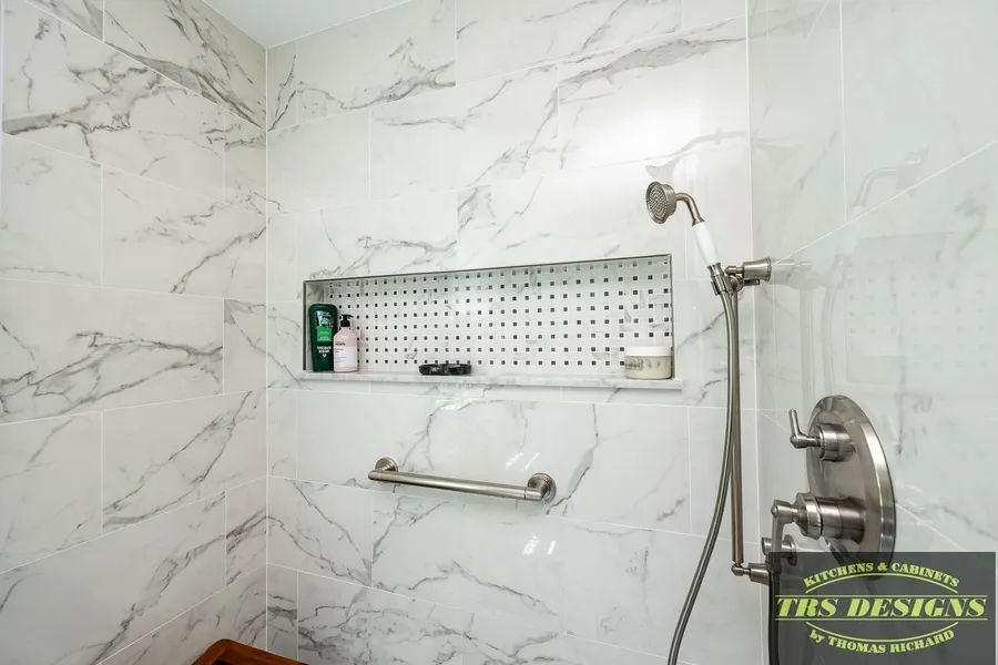A bathroom with marble walls and a shower head.
