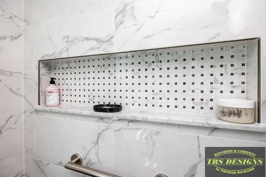 A bathroom with a marble wall and a shower niche.