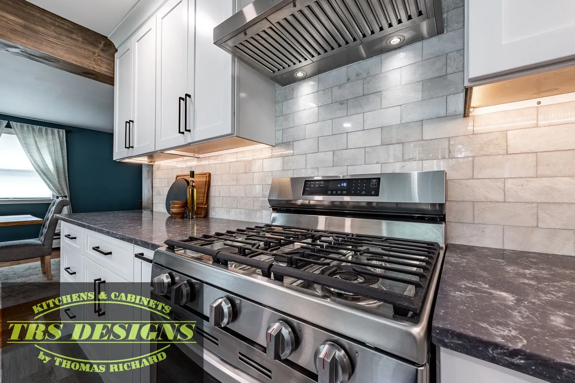 A kitchen with stainless steel appliances and white cabinets.