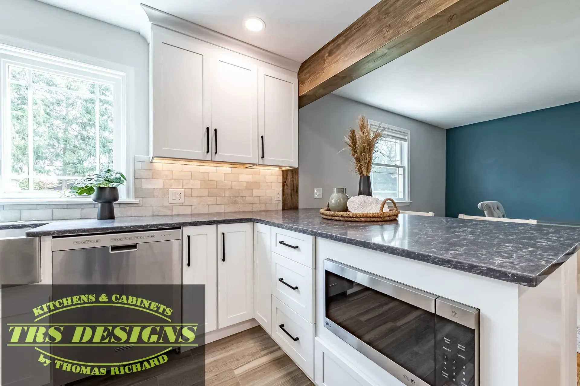 A kitchen with white cabinets and granite counter tops.