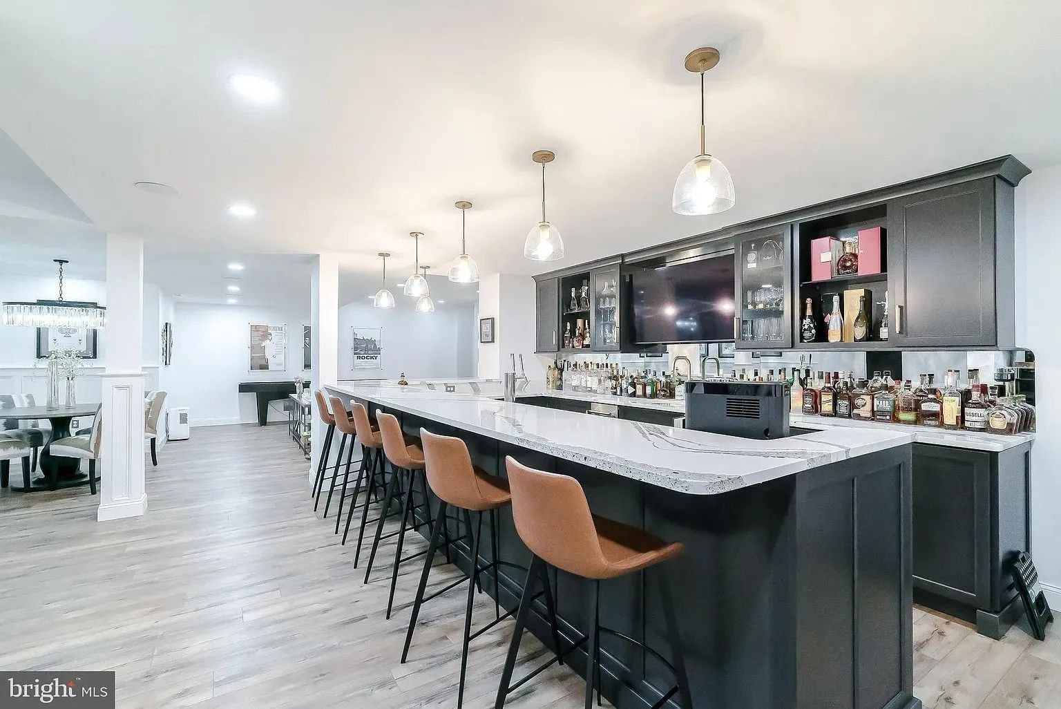 A large kitchen with a long bar and stools.