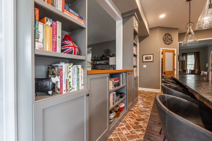 There are many books on the shelves in the kitchen.