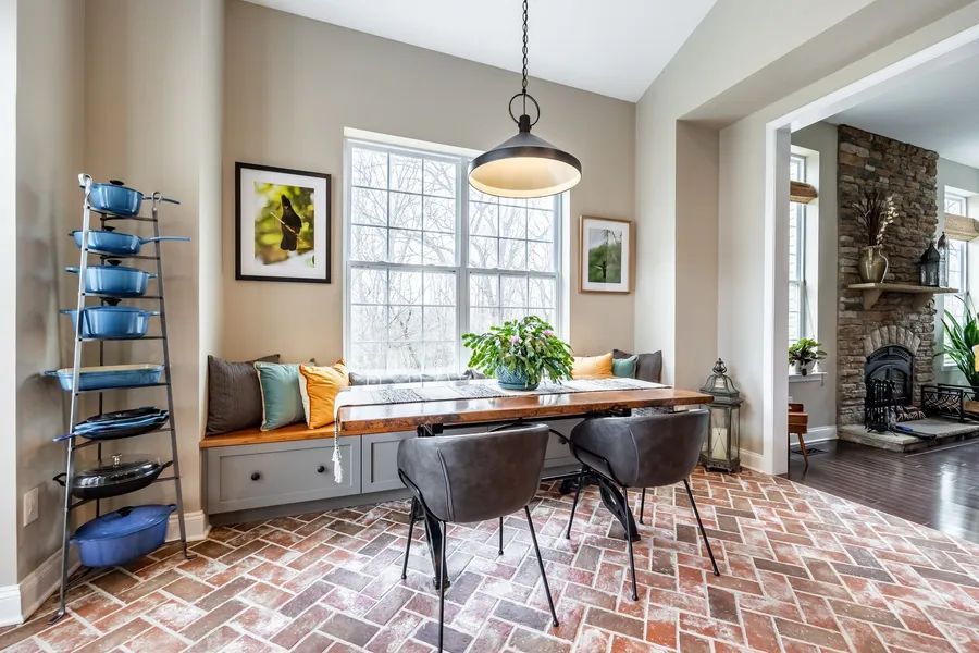 A dining room with a table and chairs and a window seat.