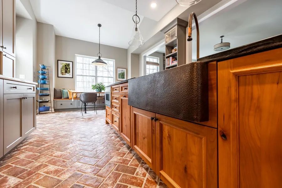 A kitchen with a large sink and wooden cabinets.