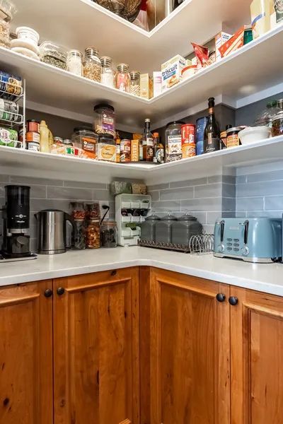 A kitchen with wooden cabinets , a toaster oven, and a coffee maker.