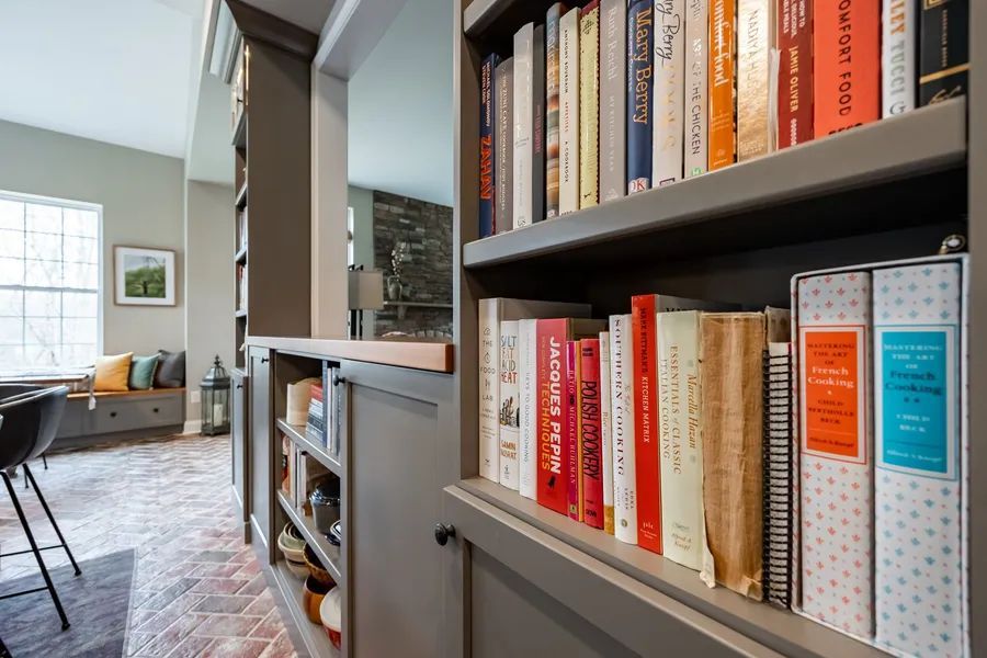 A bookshelf filled with lots of books in a living room.