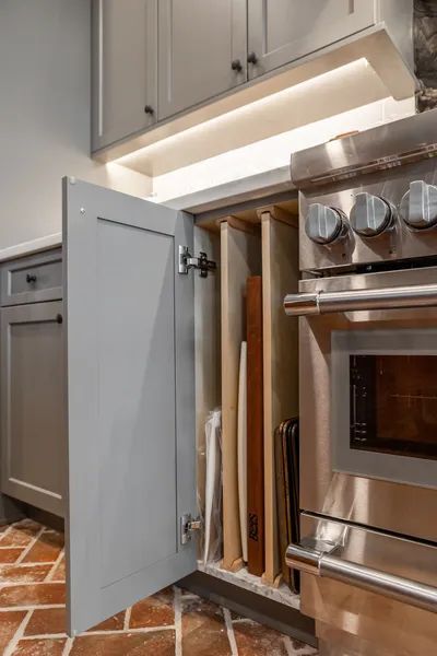 A kitchen with stainless steel appliances and cabinets with the door open.