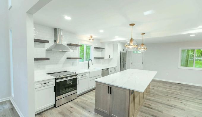 A kitchen with white cabinets, stainless steel appliances.