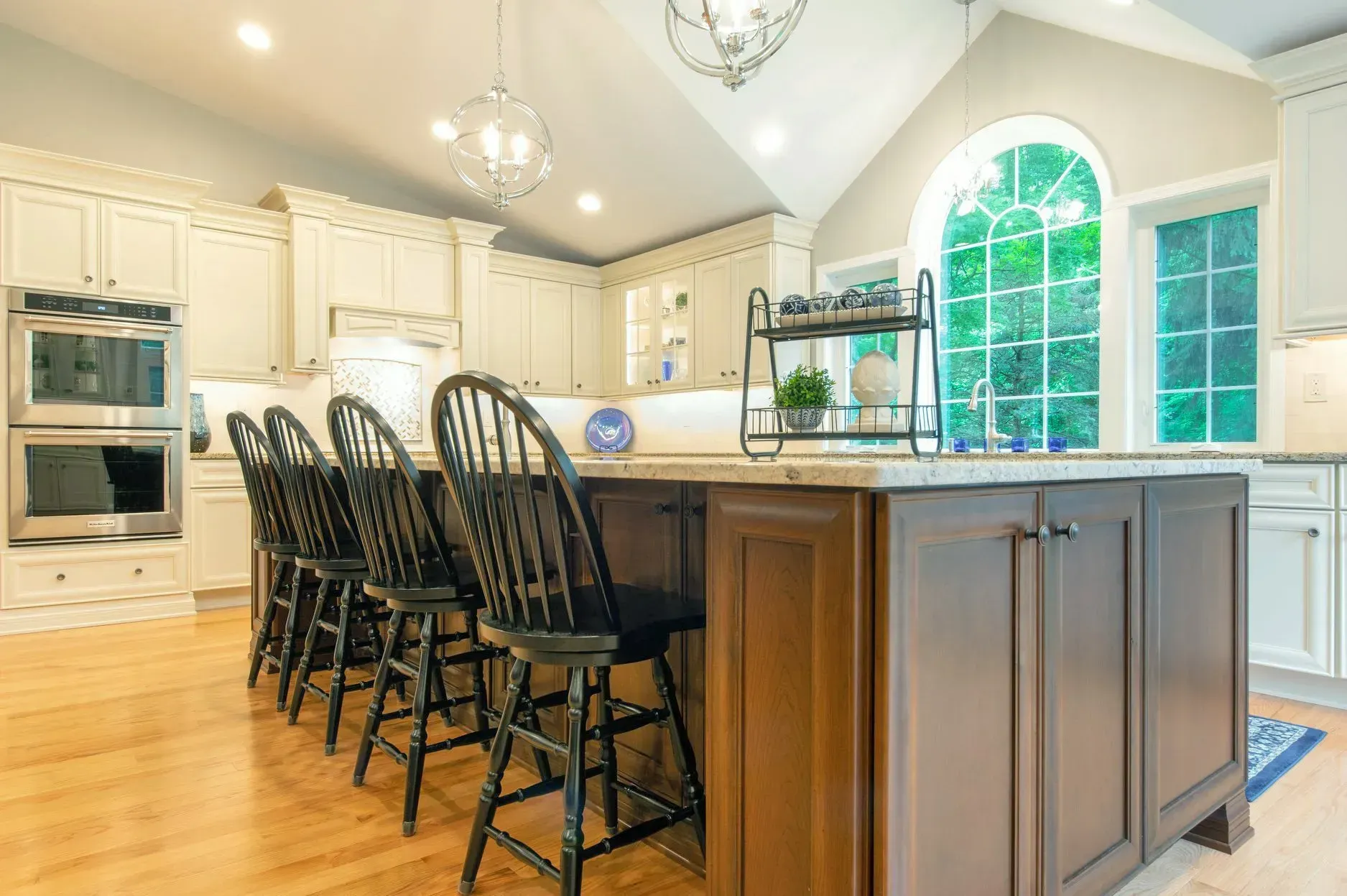 A kitchen with a large island and lots of black chairs.