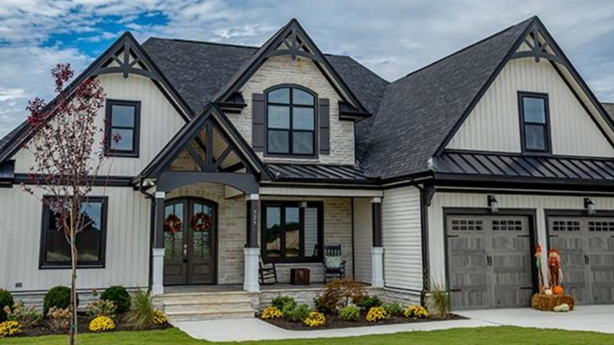 A large white and black house with a gray roof.