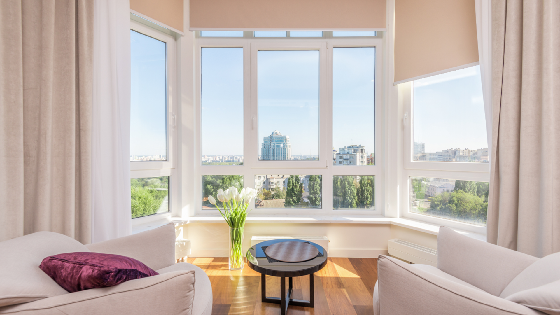 There is a large window in the living room with a view of the city.