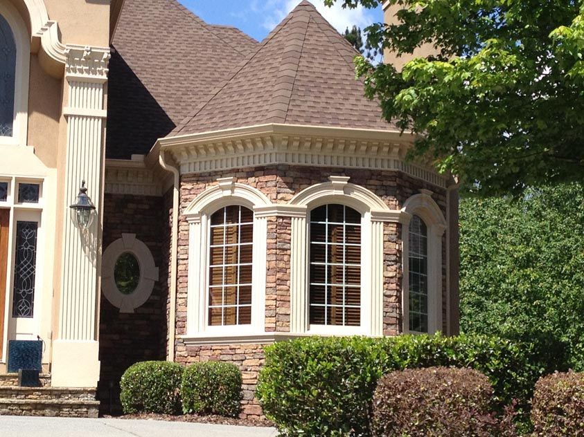 A large house with arched windows and a brown roof