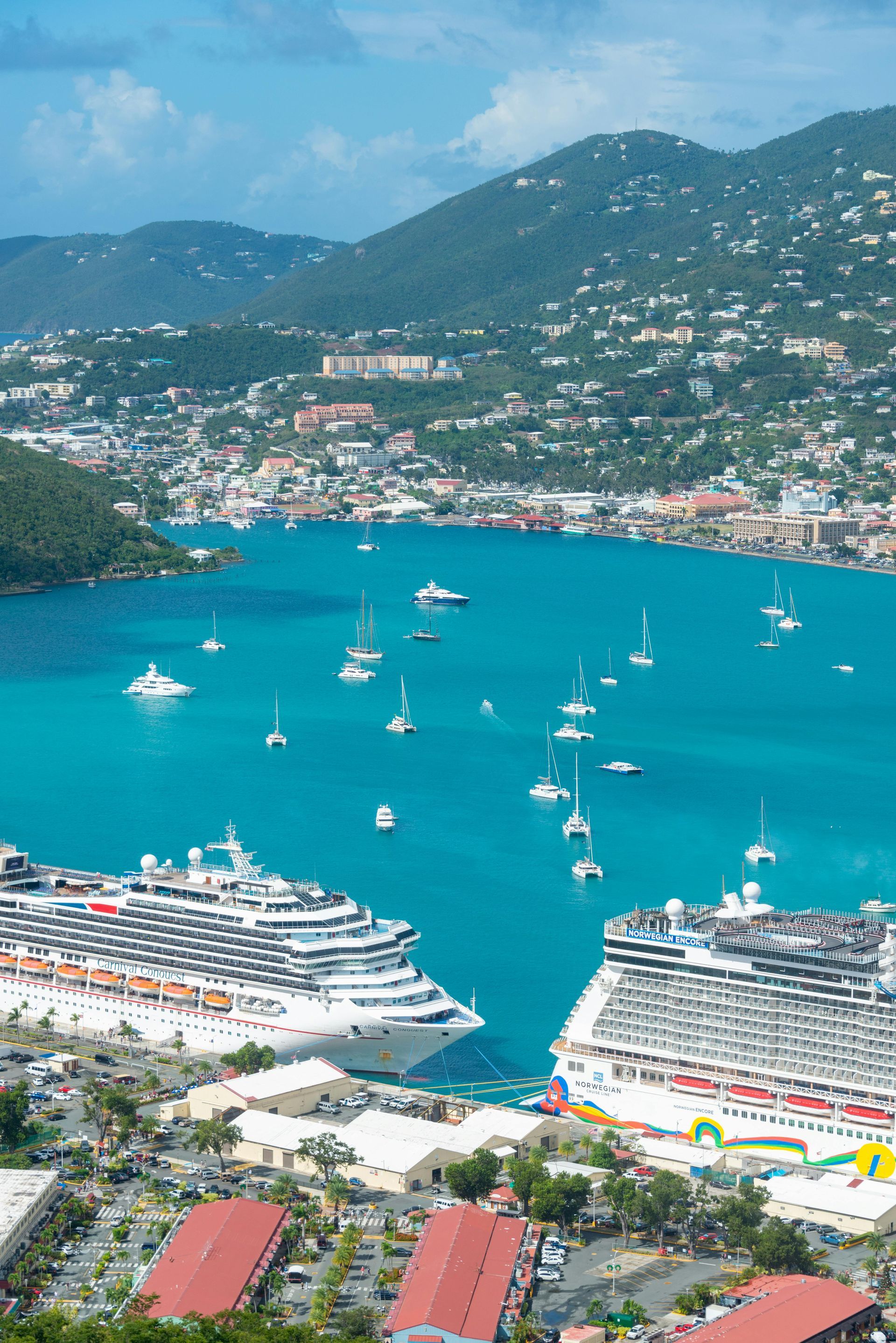 A large body of water with boats in it and mountains in the background.