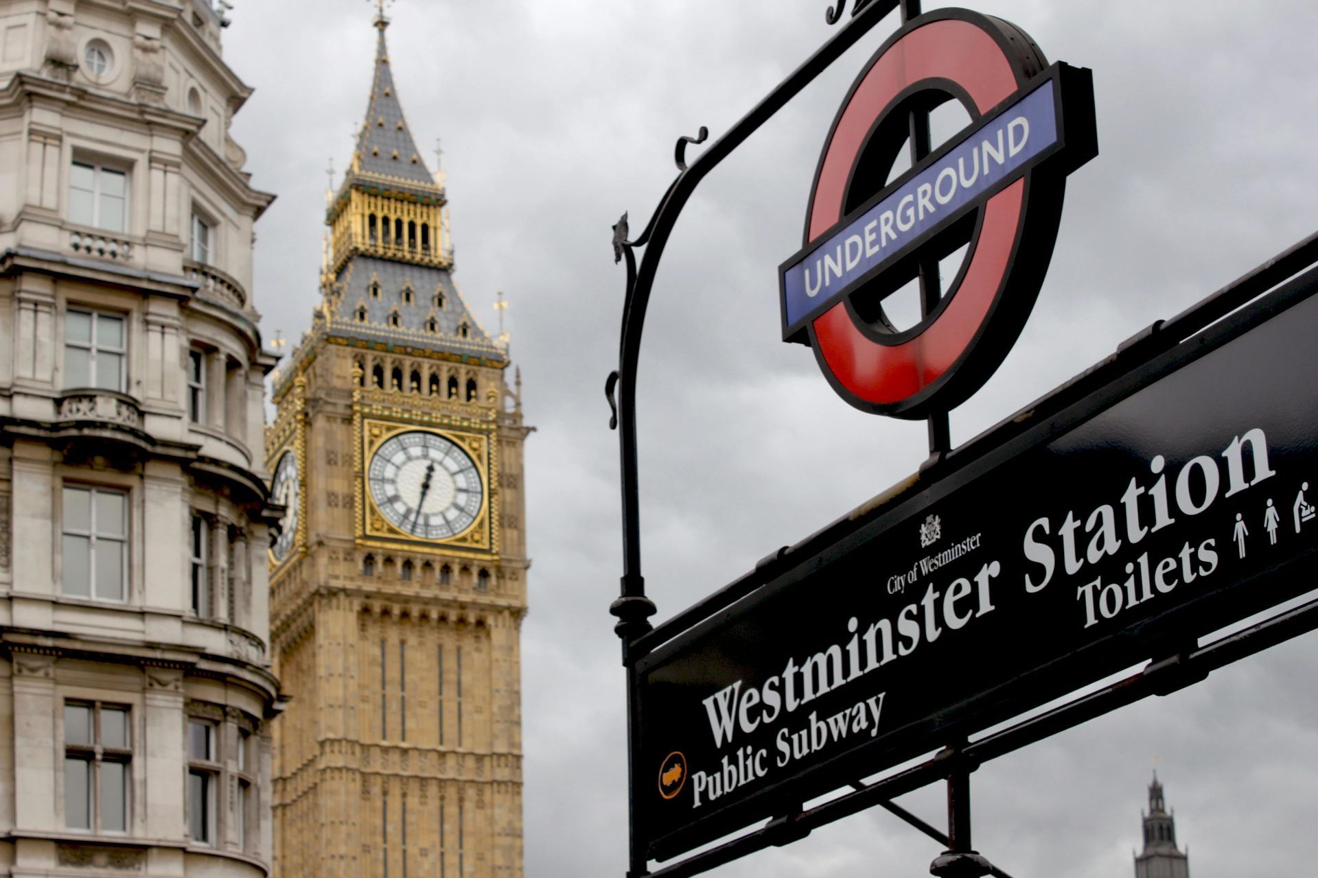 A sign for westminster station is in front of big ben