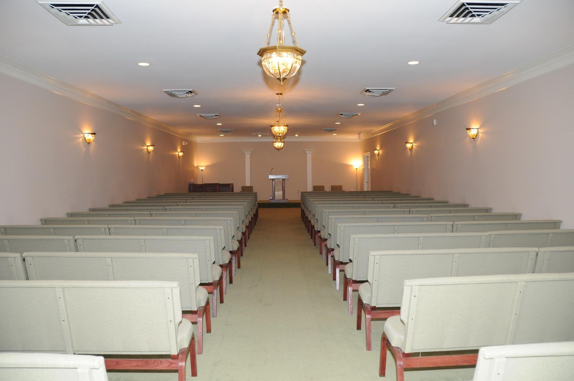 An empty church with rows of chairs and a chandelier hanging from the ceiling.
