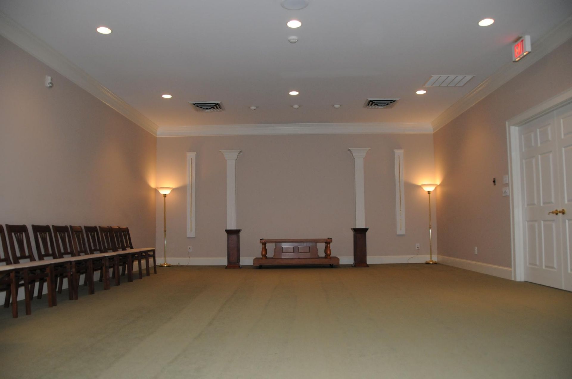 An empty room with a row of chairs and a podium in the middle.