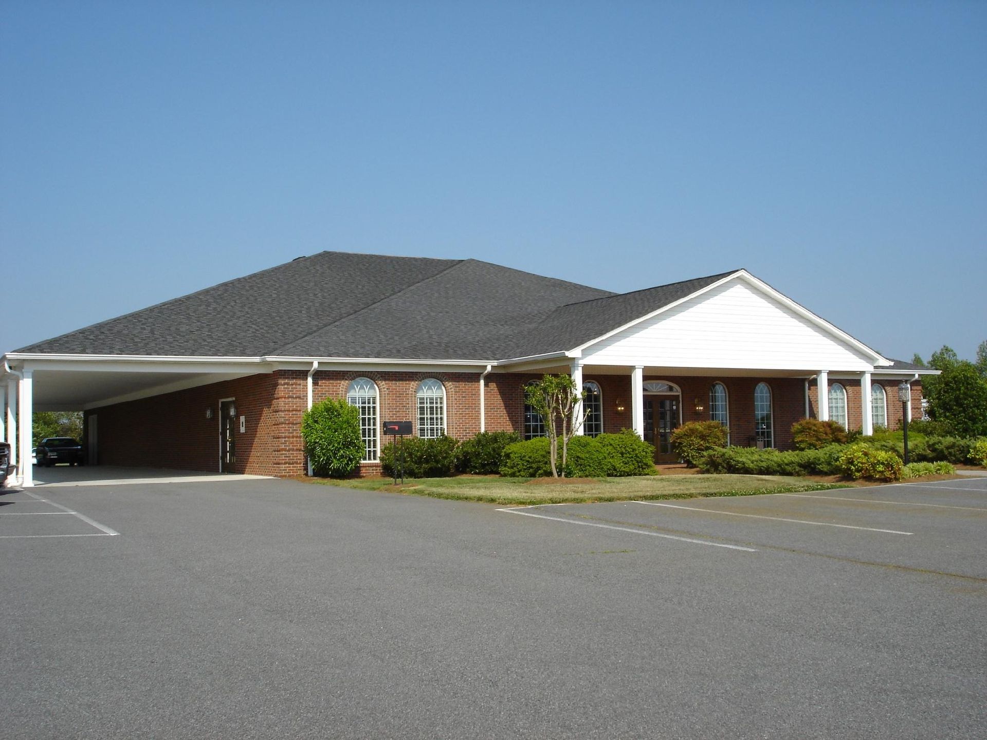A large brick building with a carport in front of it