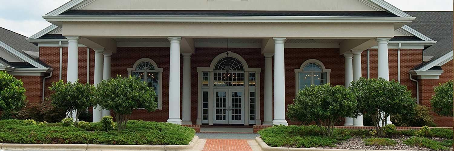 A large brick building with a porch and columns