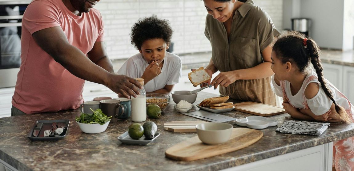 A family is preparing food together in a kitchen.