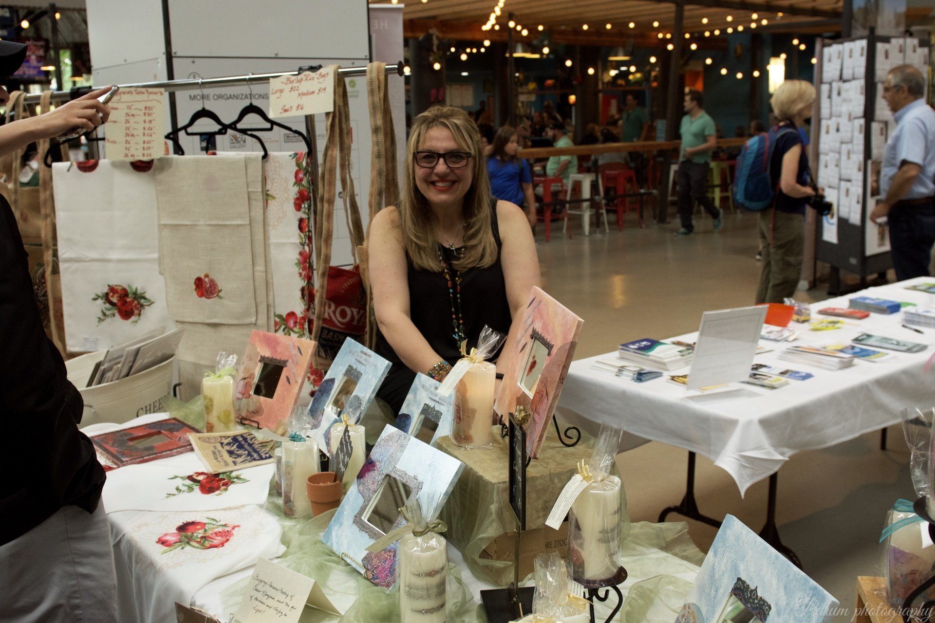 A woman is sitting at a table with candles and cards on it.