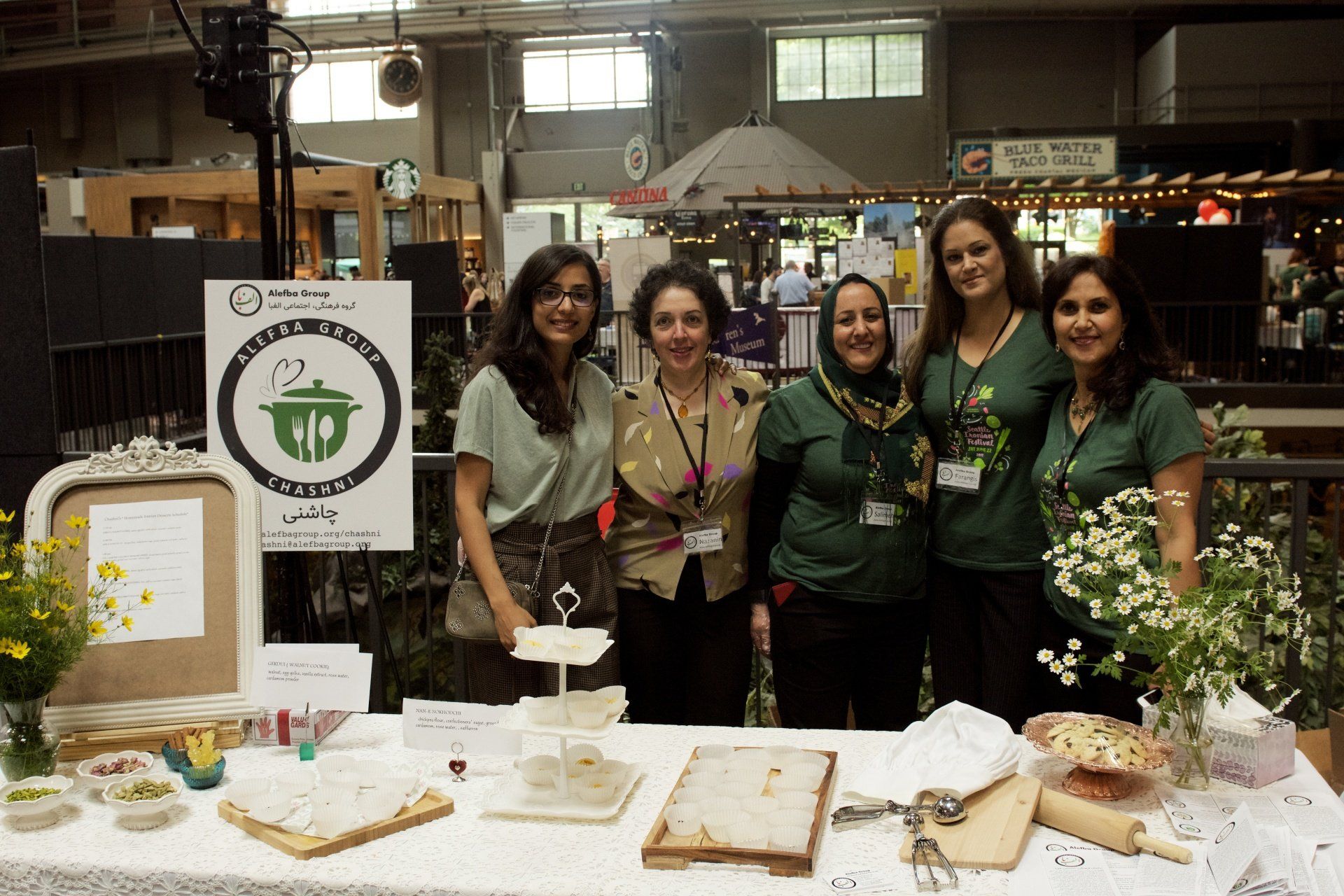 A group of women are posing for a picture in front of a table