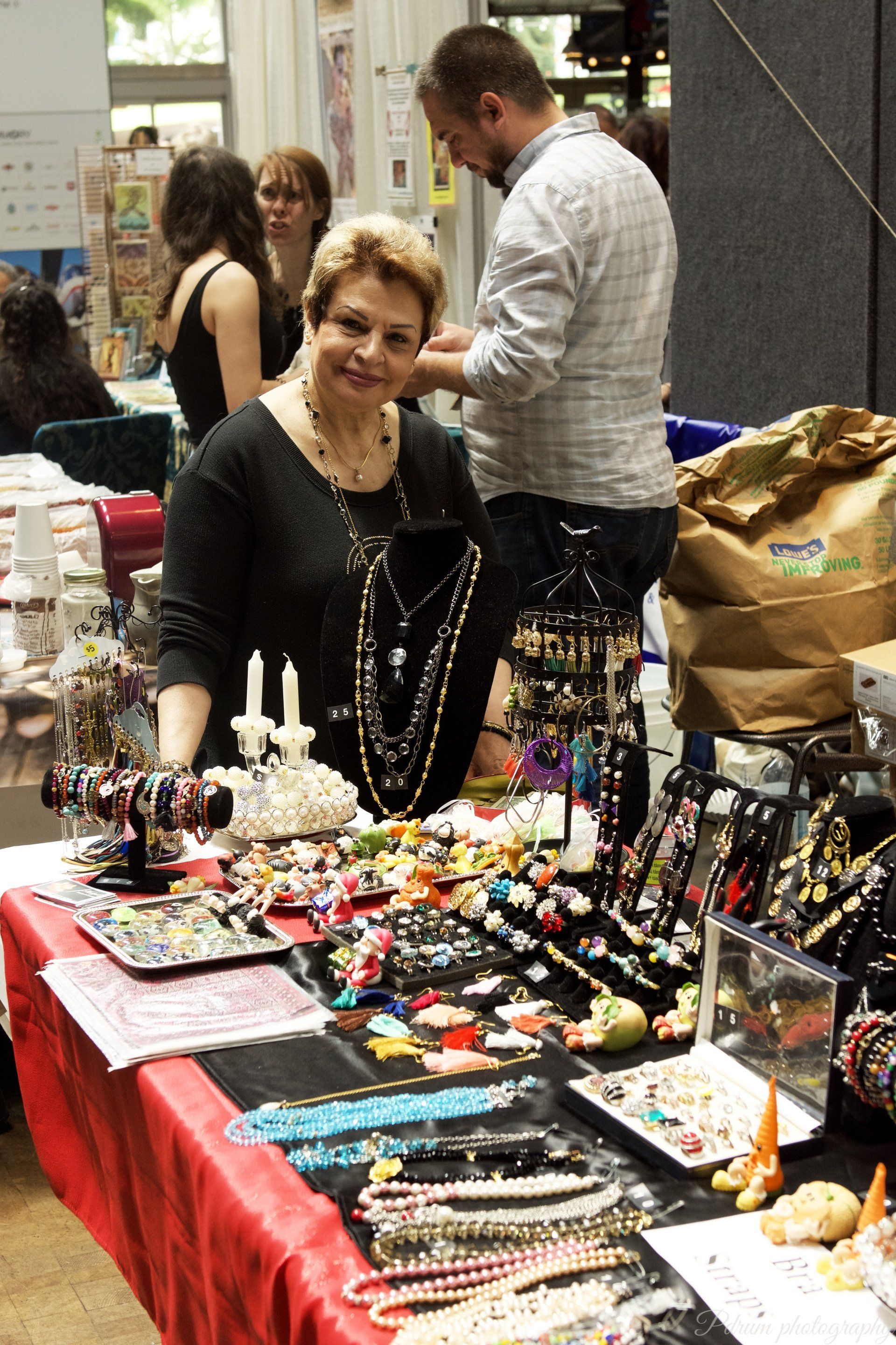 A woman stands behind a table full of jewelry