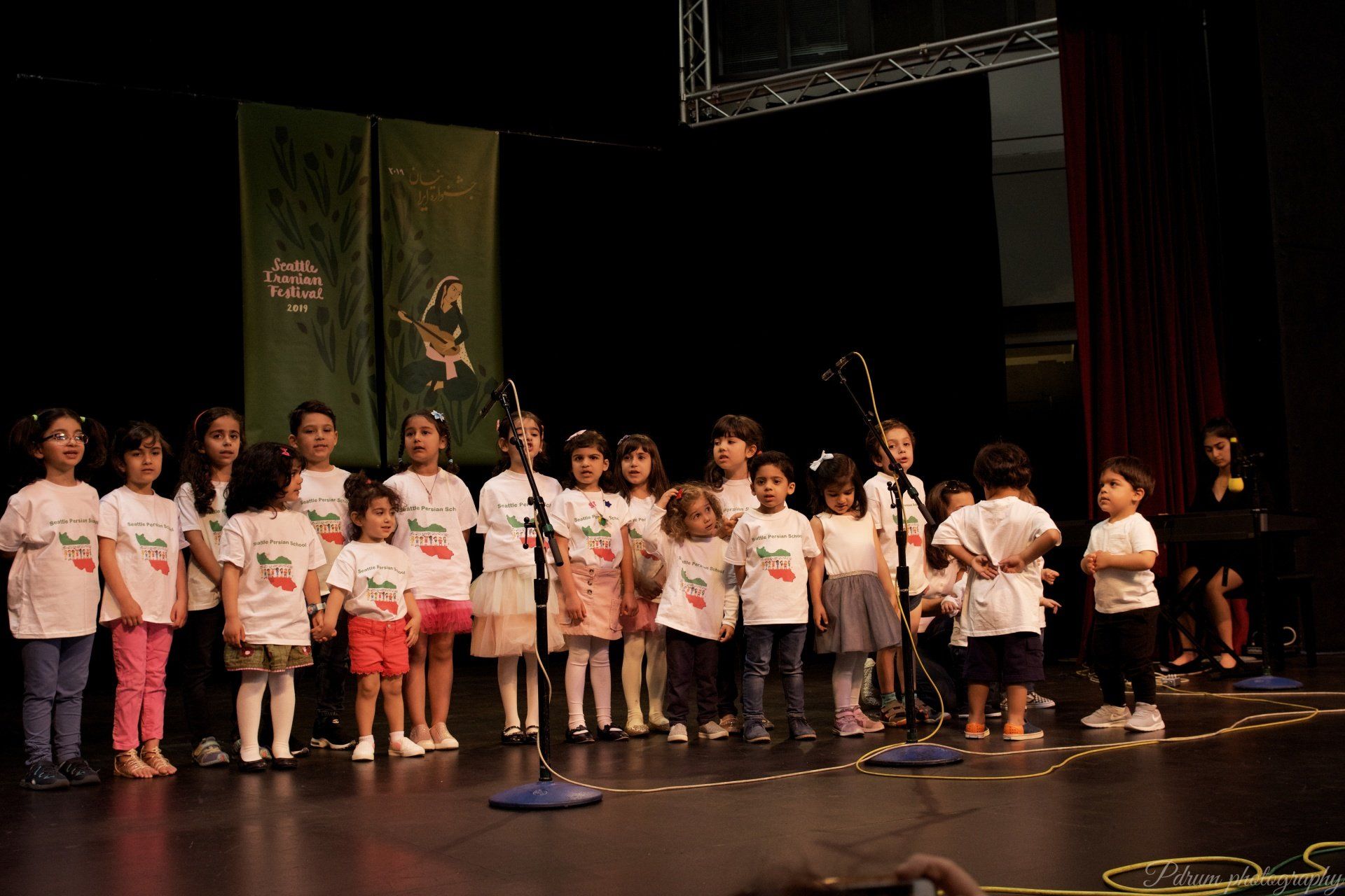 A group of children singing into microphones on a stage