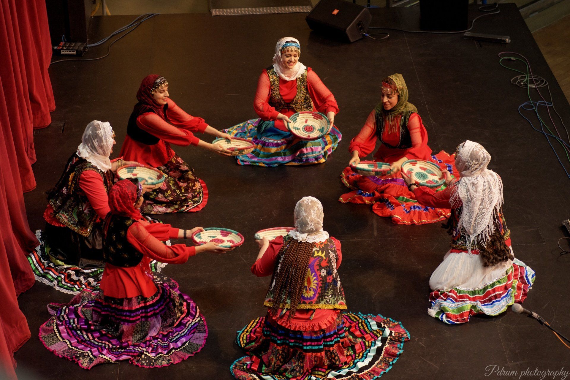 A group of women are sitting in a circle on a stage