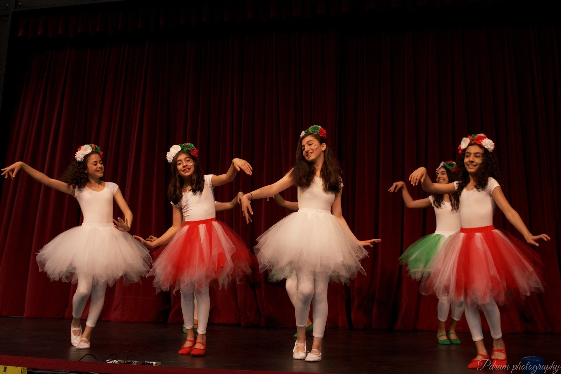 A group of young girls are dancing on a stage.