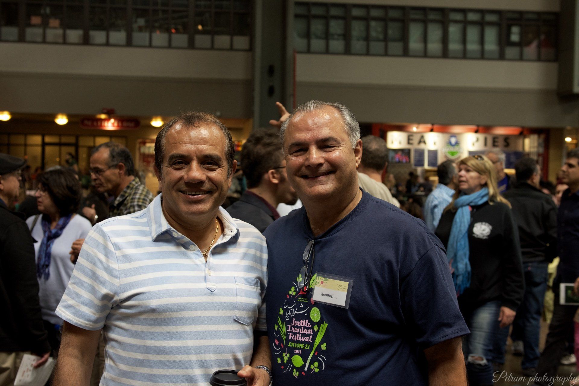 Two men are posing for a picture in front of a crowd.