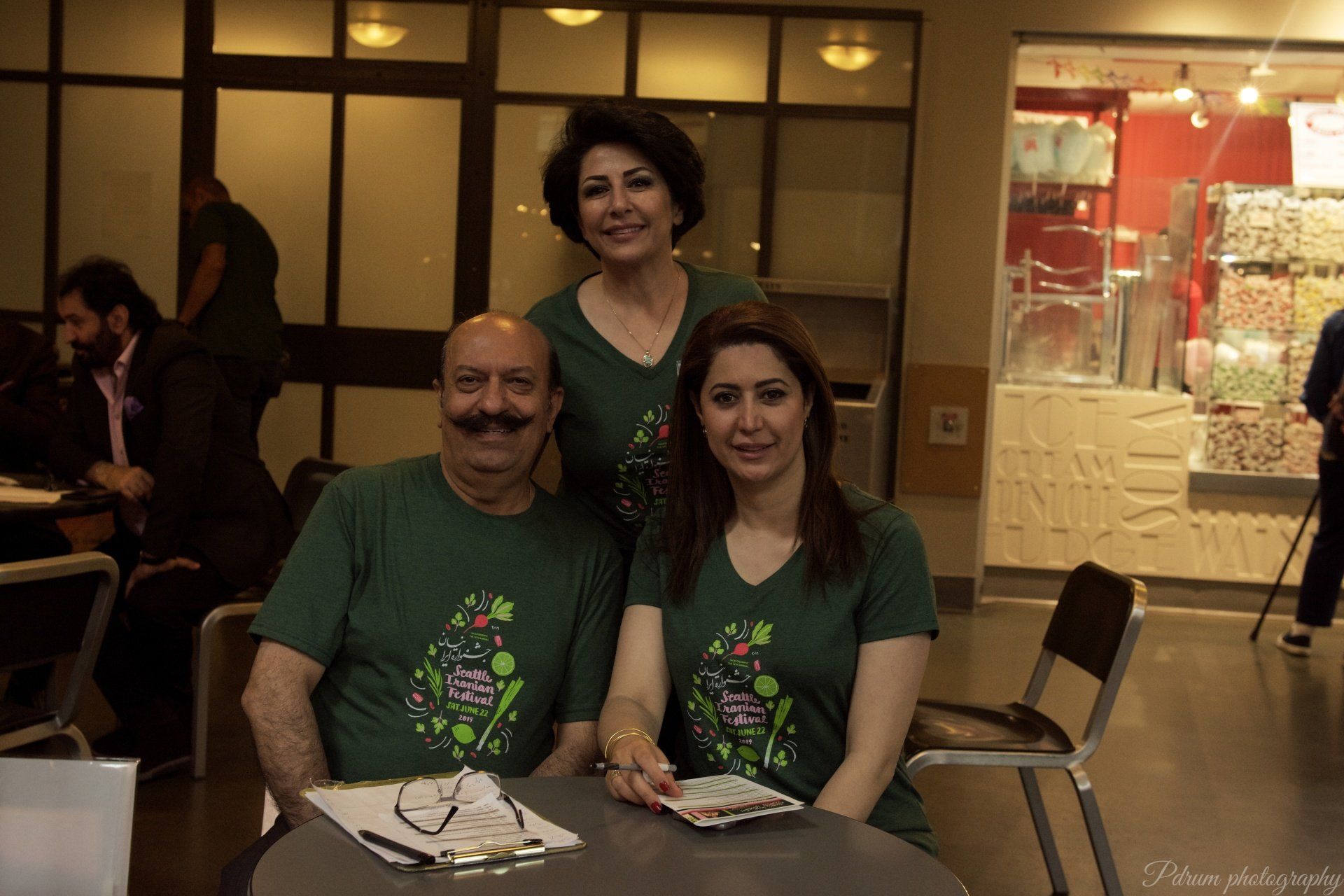 A man and two women are posing for a picture while sitting at a table.