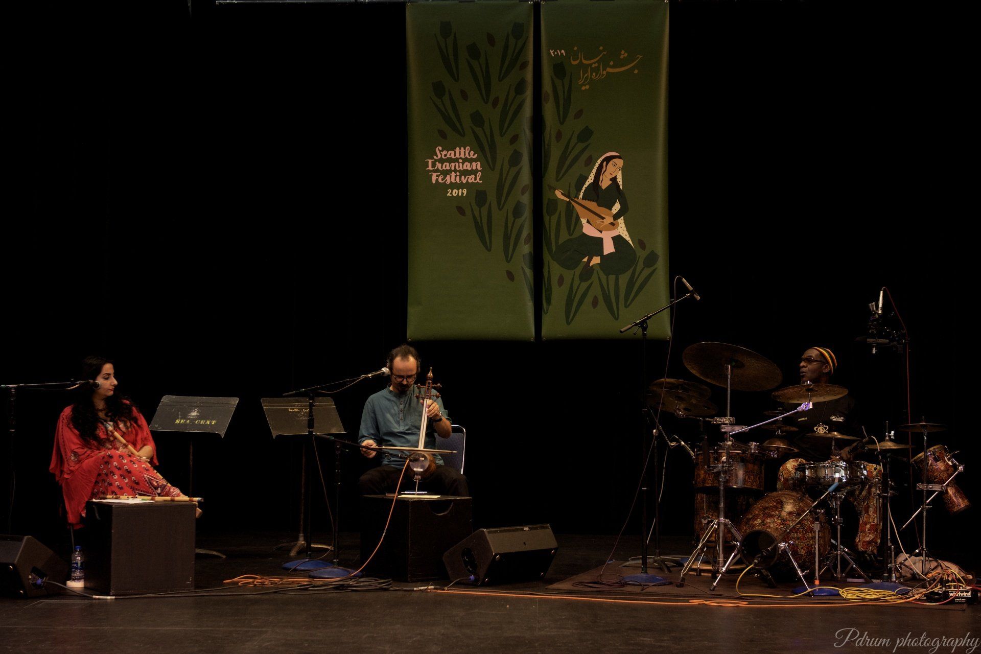 A man and a woman are playing instruments on a stage.