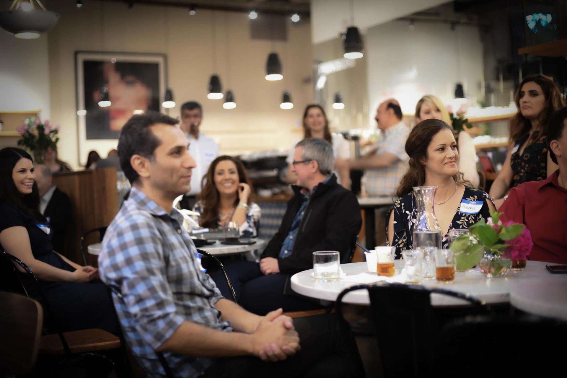 A group of people are sitting at tables in a restaurant.