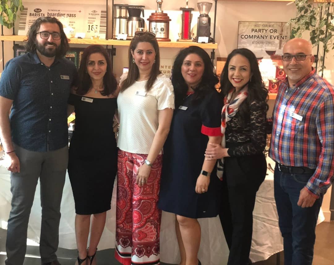 A group of people posing for a picture in front of a sign that says notice