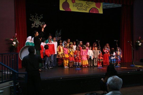 A group of children are singing on a stage at a festival