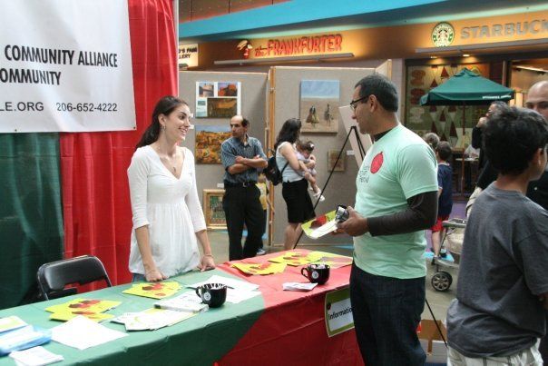 A group of people standing around a table with a sign that says community alliance community