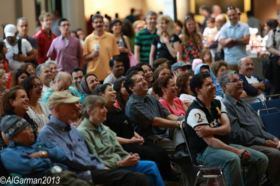 A large group of people are sitting in chairs and laughing.