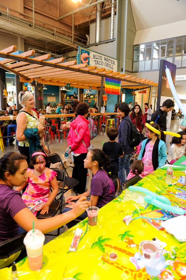 A group of people are sitting around a table in a mall.