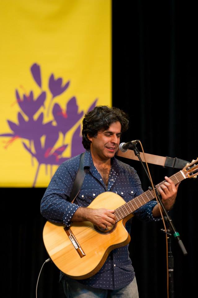 A man is playing a guitar and singing into a microphone