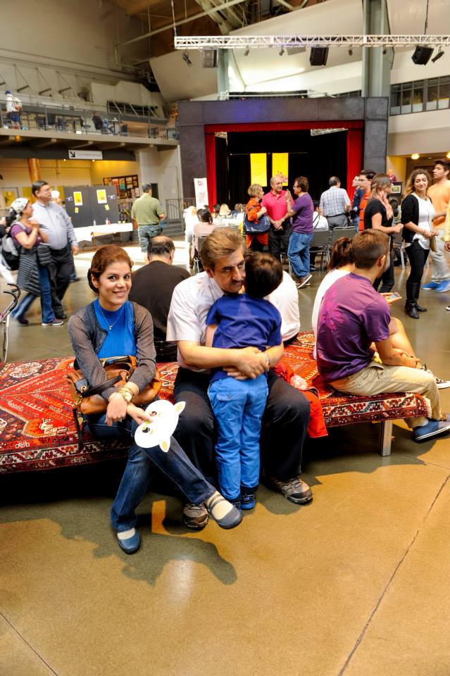 A group of people are sitting on a bench in a room.
