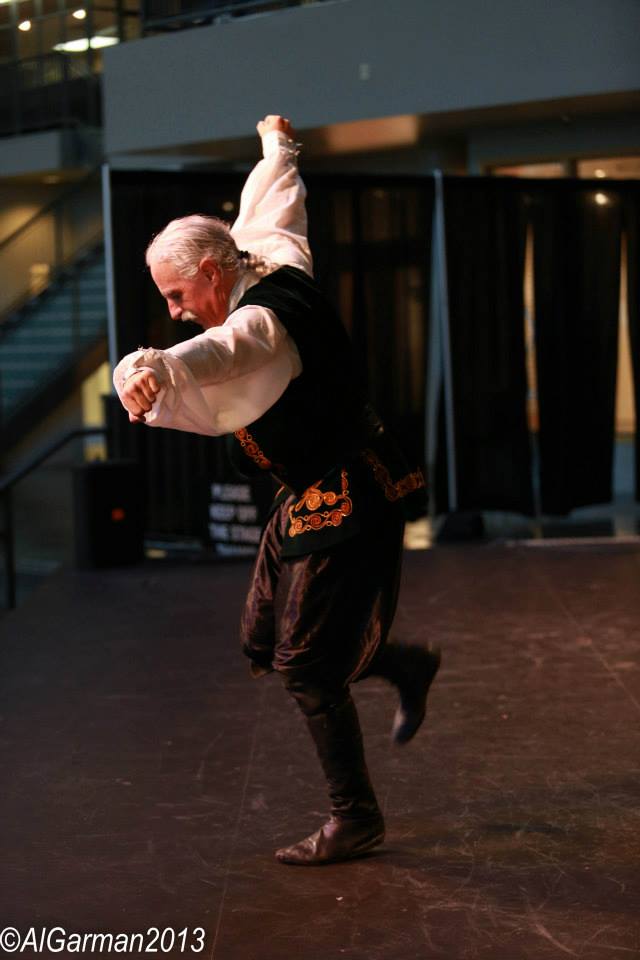 A man in a costume is dancing on a stage.