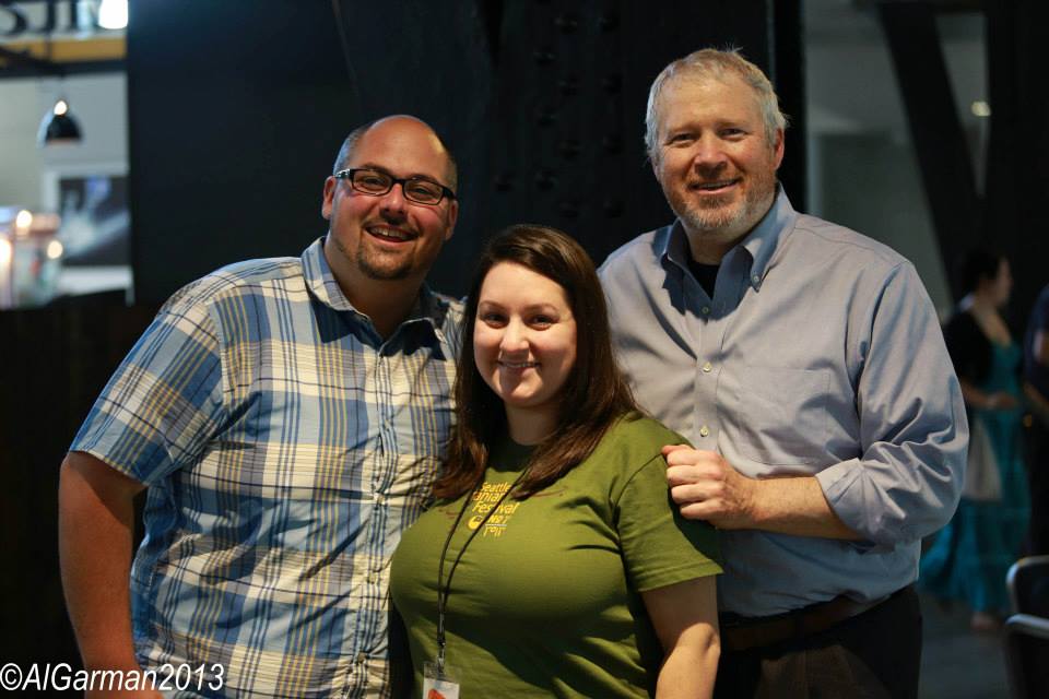 Two men and a woman are posing for a picture together