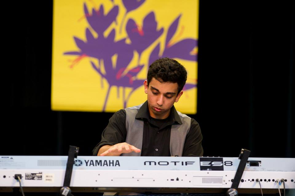 A man is playing a yamaha motif keyboard