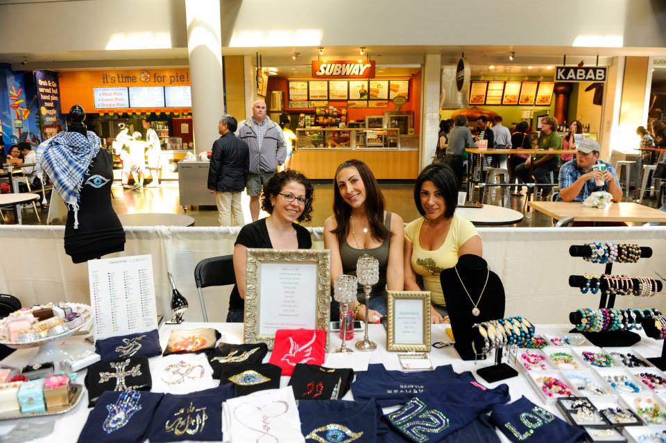 A group of women are standing around a table in a mall