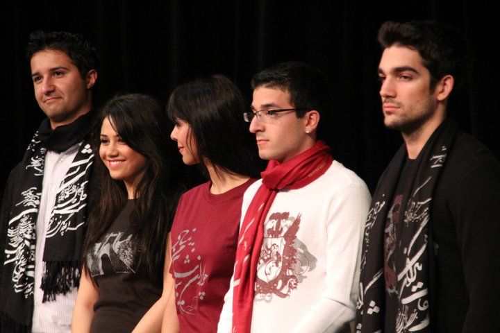 A group of people standing in front of a black background