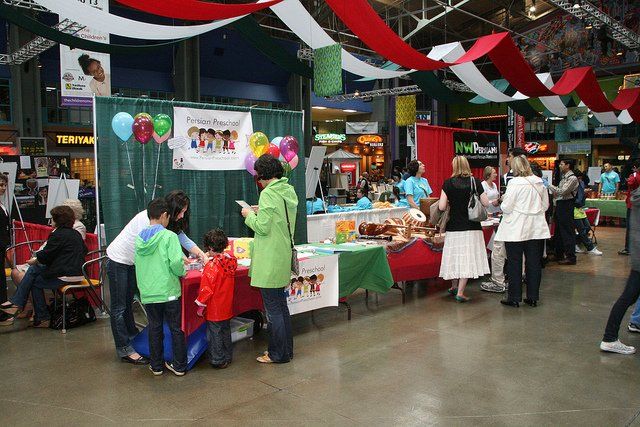 A group of people are gathered around a table with balloons on it